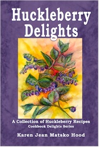 Huckleberry Delights Cookbook Cover of a cookbook featuring a colorful illustration of a huckleberry plant.