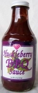 Bottle of Huckleberry BBQ sauce with purple label and diamond logo.