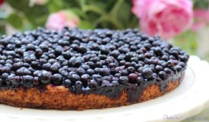 Blueberry cake with pink flowers background.