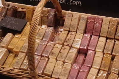 Basket filled with neatly stacked rectangular soap bars in various pastel colors.