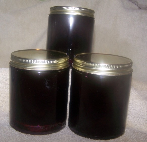 Three jars filled with a dark substance, sealed with metal lids.