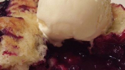 A dessert with vanilla ice cream and berry cobbler.
