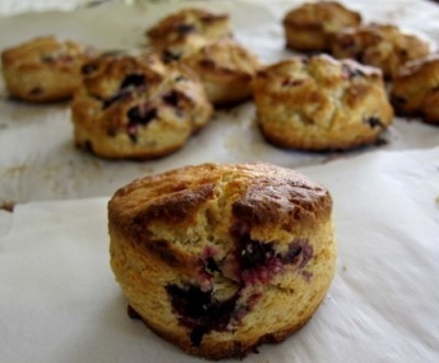 Freshly baked blueberry scones on parchment paper.