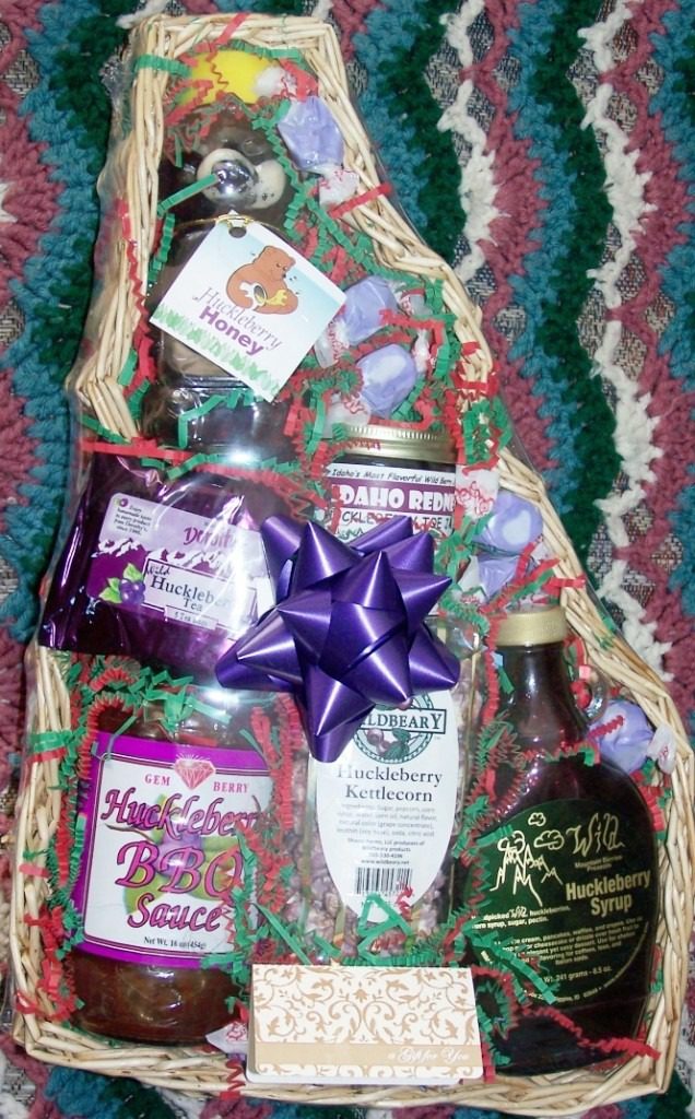 A festive gift basket with wine, chocolates, and decorative ribbons.