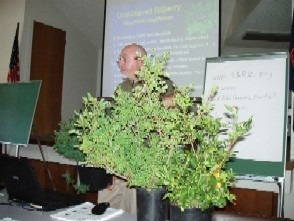 Man presenting plants in a classroom setting.