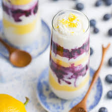 Layered blueberry and lemon parfait in a glass with fresh blueberries.