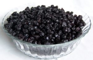 Bowl of dried blueberries on white background.