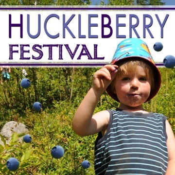 Child enjoying the Huckleberry Festival with fresh berries.