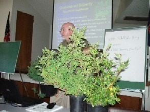 Man presenting plants in a classroom setting.