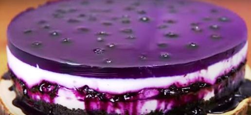 Close-up of a layered blueberry dessert with jelly and cream.