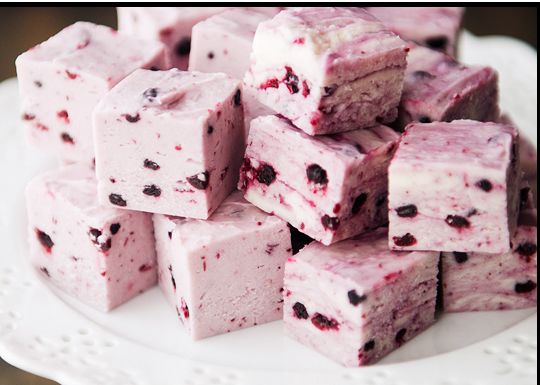 Close-up of pink cranberry nougat cubes on a plate.