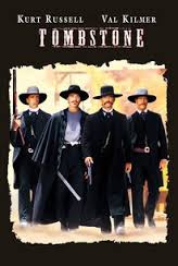 Four cowboys in black attire posing together.