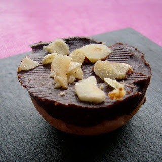 Chocolate cupcake topped with banana slices on a dark surface.