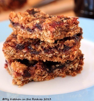 Stack of homemade oat and berry bars on a plate.