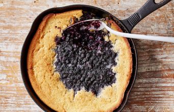Skillet blueberry cobbler with a golden crust and juicy berries in the center.