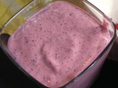 A close-up of a thick, purple smoothie in a glass container.