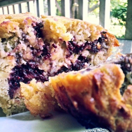 Close-up of a moist blueberry muffin with a crumbly top.