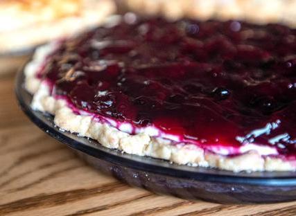 Close-up of a blueberry cheesecake with a glossy fruit topping.