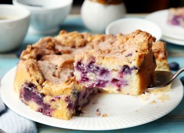 Slice of berry cake on a white plate.