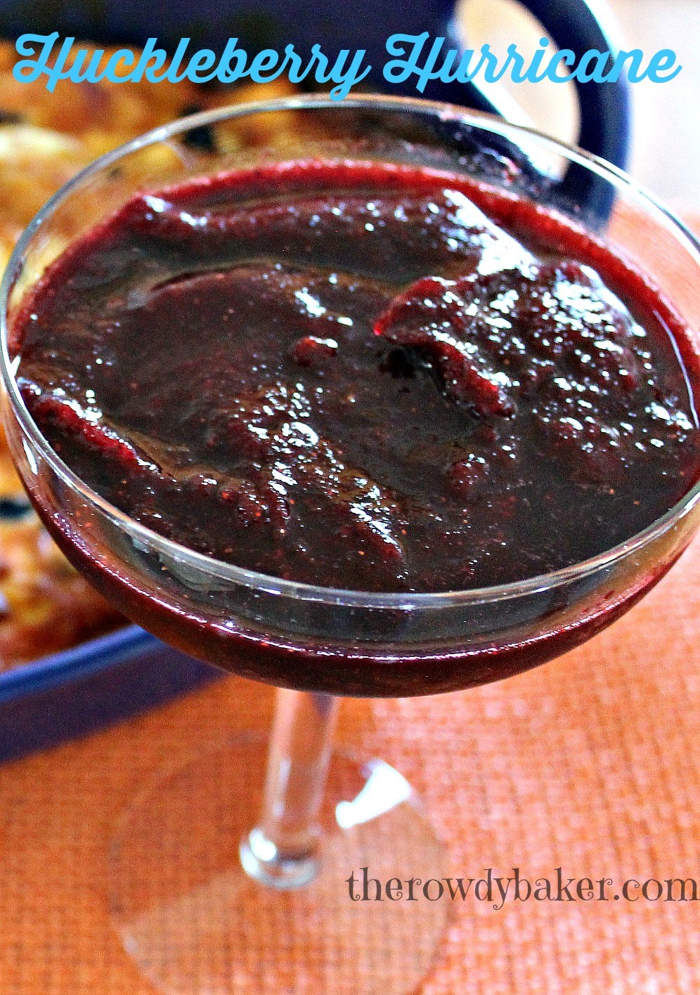 A glass filled with thick, dark red sauce or jam.