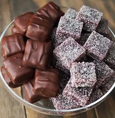 A plate with chocolate-covered and coconut-coated square sweets.