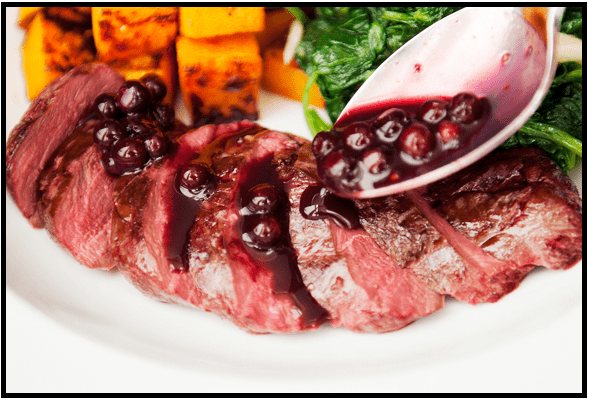 Sliced steak topped with a rich berry sauce and served with grilled vegetables.